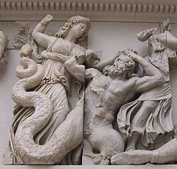 Detalle escultórico en relieve que representa figuras mitológicas combatiendo.