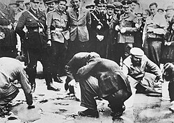 Fotografía histórica de judíos forzados a limpiar calles en Austria en 1938.