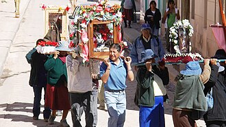 Personas participando en una festividad religiosa tradicional al aire libre.