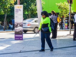 Persona utilizando baldosas podotáctiles en un espacio público