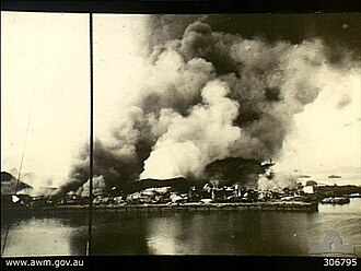 Infraestructura portuaria en llamas tras ser destruida por las fuerzas neerlandesas en retirada.