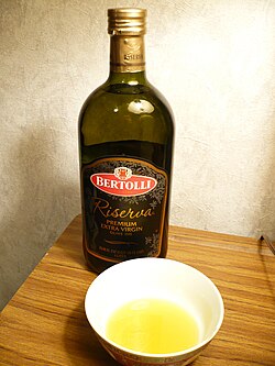 Una botella y un cuenco de aceite de oliva Bertolli reserva extra virgen.