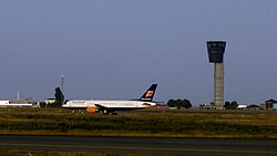 Torre de control y aeronave comercial en las instalaciones aeroportuarias