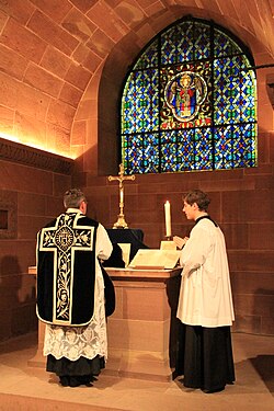 Sacerdote celebrando misa de réquiem con ornamentos negros