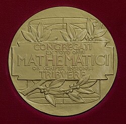 Reverso de la Medalla Fields con la inscripción y la figura geométrica