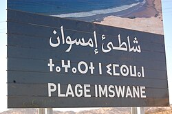 Cartel multilingüe en una playa