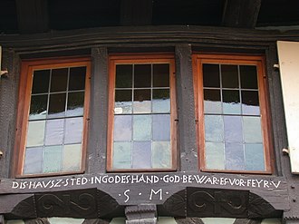 Inscripción en alsaciano en una ventana de la localidad de Eguisheim.