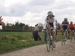 Ciclistas rodando sobre un tramo de pavé durante la París-Roubaix 2006