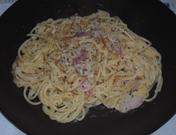 Plato de espaguetis con una variante de carbonara elaborada con cebolla, nata y bacon.