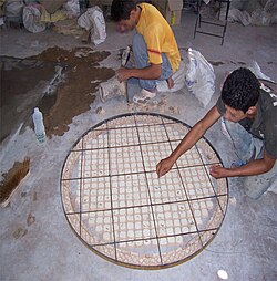 Artesanos trabajando en la elaboración de una mesa de mosaico