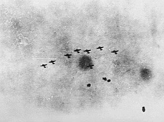 Navío de guerra aliado siendo atacado por aviones bombarderos en altamar.