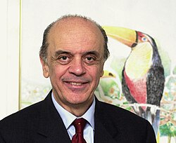 José Serra junto al símbolo del tucán del partido PSDB