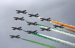 Los Frecce Tricolori realizando figuras en el aire con humo de colores.