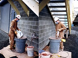 Operario realizando la mezcla manual de cemento con agua y agregados.