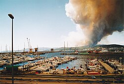 Zona boscosa afectada por un incendio próximo a edificaciones e infraestructura.