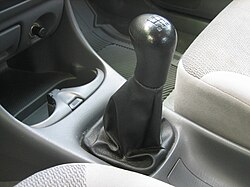 Una palanca de cambios montada en el piso en un coche de pasajeros moderno con una transmisión manual.