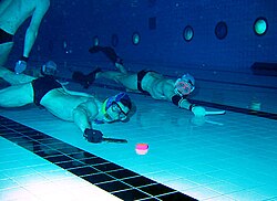 Jugadores practicando hockey subacuático en una piscina