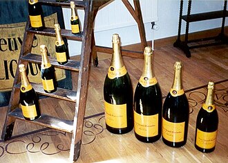 Diferentes tamaños de botellas de champán sobre el suelo