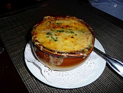 Sopa de cebolla gratinada francesa con costra de queso dorado