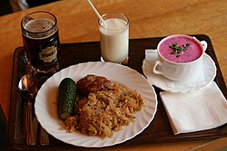 Un almuerzo típico letón con sopa fría de remolacha, chucrut, chuleta, pepinillo, kéfir y kvas.