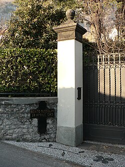 Entrada a la Villa Belmonte con una cruz negra marcando el lugar