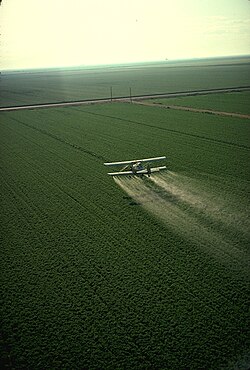 Avioneta vertiendo plaguicidas mediante el sistema de aplicación aérea.