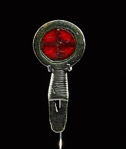 Objeto de bronce con ámbar rojo