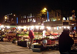 Actividad comercial nocturna en el mercado de Whitechapel