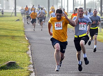 Participantes corriendo hacia la línea de meta durante una competición deportiva.