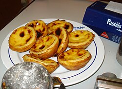 Pastel de Belém espolvoreado con canela y azúcar glass