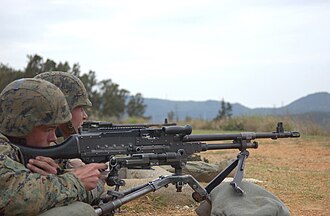 Miembros de las fuerzas armadas operando una ametralladora M240.