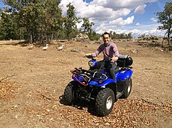 Joven montando en un quad en un ambiente rural