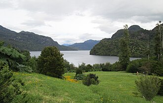 Fotografía del Lago Riesco rodeado por montañas y vegetación nativa en la región de Aysén.
