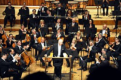 Director y músicos actuando en el Barbican Hall