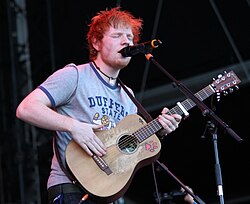 Ed Sheeran tocando la guitarra en un festival