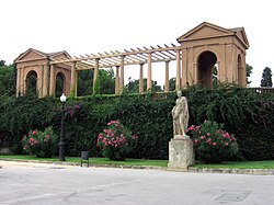 Estatua y pérgola decorativa en la entrada al recinto