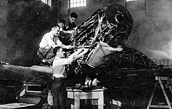 Estudiantes de ingeniería aeronáutica junto a un avión histórico Spitfire