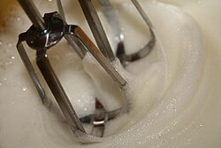 Proceso de elaboración de merengue en una máquina batidora.