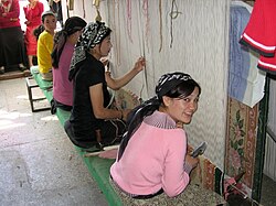 Jóvenes uigures fabricando alfombras