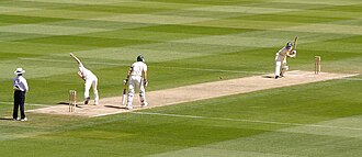 Partido de críquet en un campo abierto