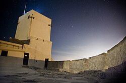 Visión nocturna de la batería este y torre del castillo