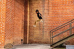 Persona realizando un movimiento de parkour al aire libre