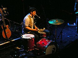 Miembros del grupo tocando diversos instrumentos durante una actuación en directo.