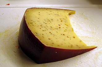 Fotografía de un queso Leyden en rodajas