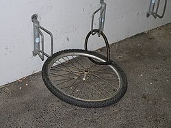 Fotografía que ilustra el hurto común de una bicicleta sujeta en la vía pública.