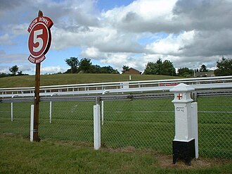 Poste que marca cinco furlongs de distancia en el hipódromo de Epsom