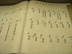 Libro de texto de Puyi mostrando alfabetos y escritura tradicional