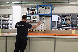 Empleado fabricando una parte de una puerta automática industrial