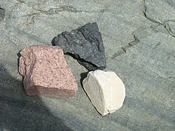 Granito rojo junto a otras muestras geológicas.