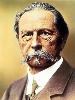 Karl Benz junto a su vehículo motorizado